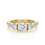 Load image into Gallery viewer, Front view of 2 Carat Round Moissanite Engagement Three Stone Ring In Yellow Gold, highlighting the brilliant center moissanite stone.