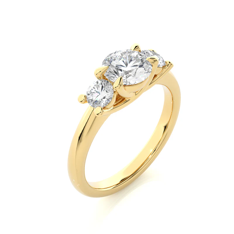 Angled view of 2 carat round moissanite three stone engagement ring in yellow gold, showcasing the band and setting