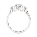 Load image into Gallery viewer, Side profile of 1.50 Ct Round Moissanite Three Stone Engagement Ring in White Gold, highlighting the brilliant center moissanite stone., highlighting the prong setting.