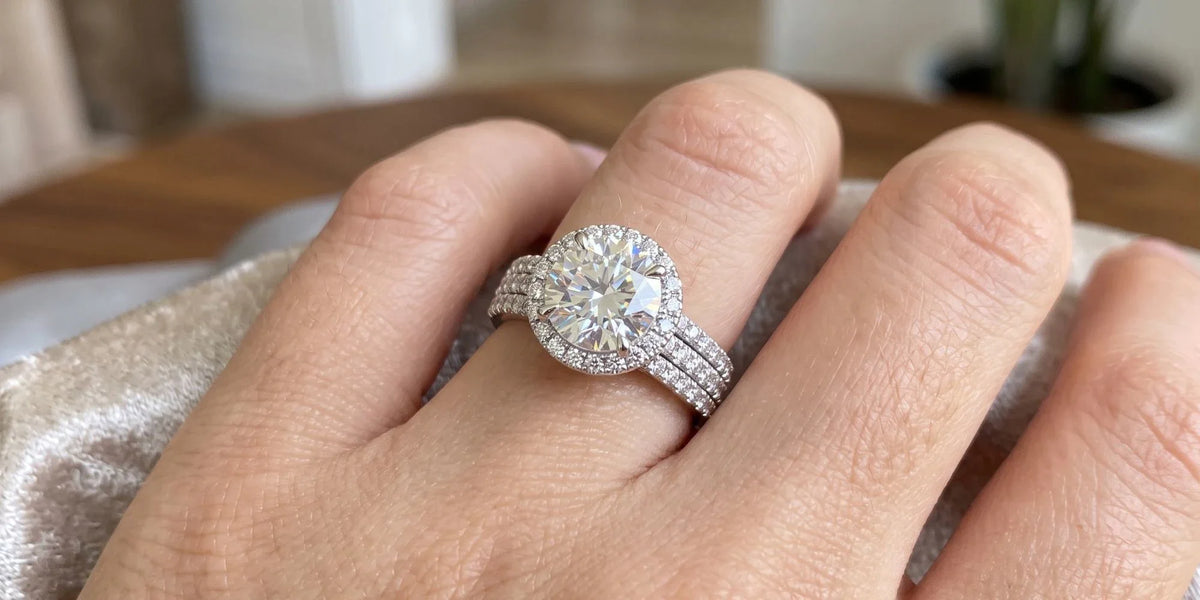A symphony of sparkle: round halo ring with a triple row moissanite band
