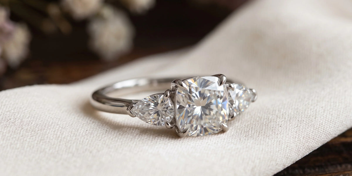 Cushion cut three stone ring with pear side moissanites: a perfect blend of romance and brilliance