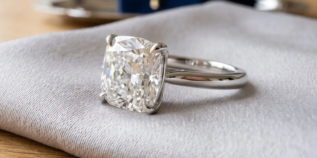 Cushion solitaire ring with gently curved cathedral shoulders