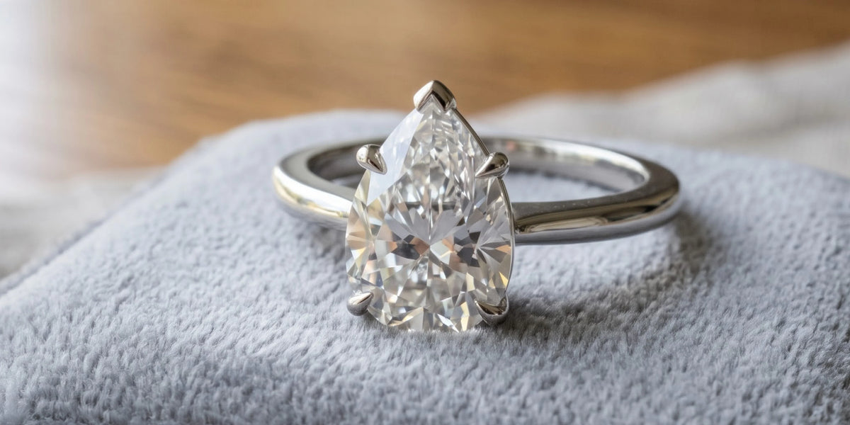 Pear cut solitaire accent ring with engraved wood grain design: nature inspired elegance with timeless romance