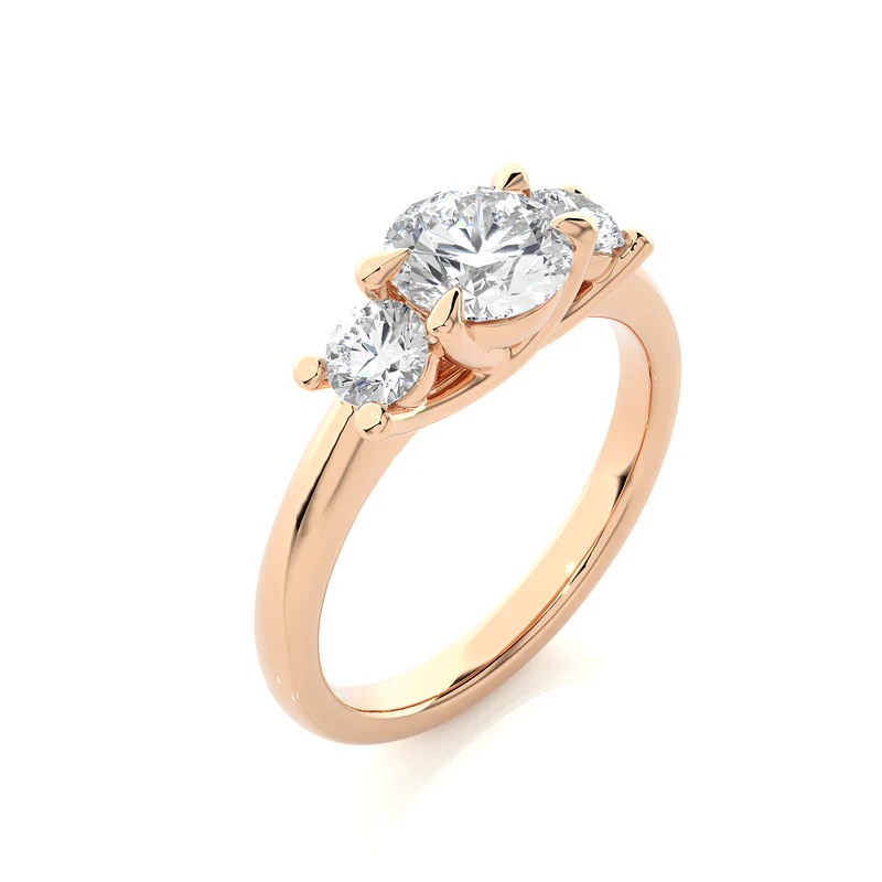 Angled view of 2 carat round moissanite three stone engagement ring in rose gold, showcasing the band and setting