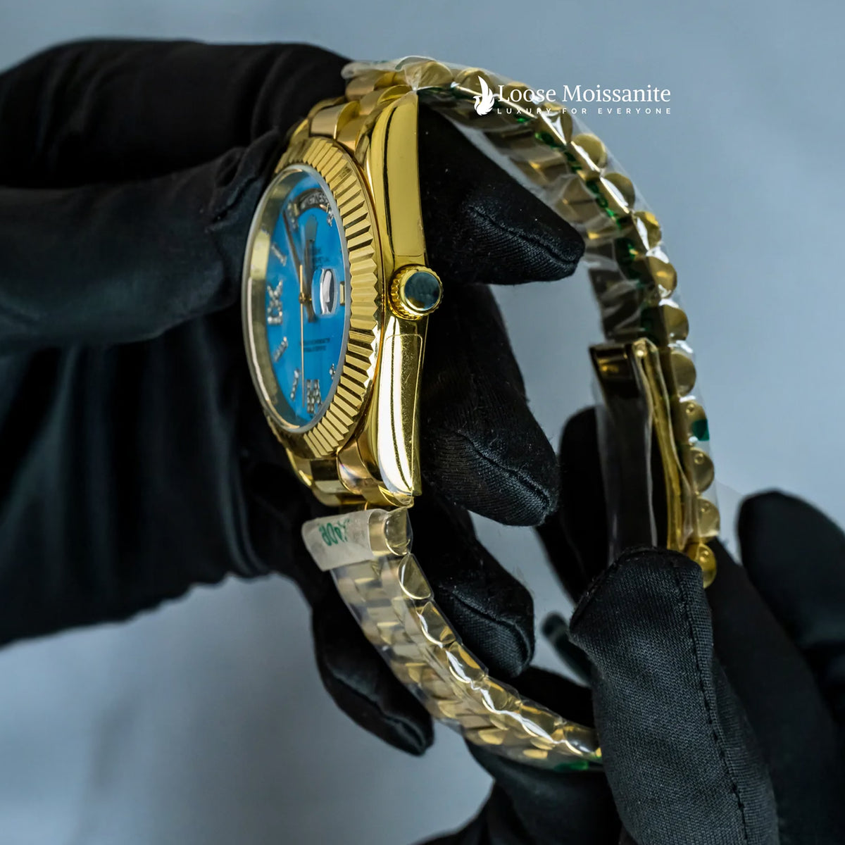 Side view of oyster perpetual day date sky blue dial plain watch in yellow gold