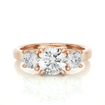 Load image into Gallery viewer, Front view of 1.50 Ct Round Moissanite Three Stone Engagement Ring In Rose Gold, highlighting the brilliant center Moissanite stone.

