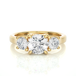 Load image into Gallery viewer, Front view of 1.50 Ct Round Moissanite Three Stone Engagement Ring In Yellow Gold, highlighting the brilliant center Moissanite stone.
