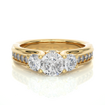 Load image into Gallery viewer, Front view of 2 Ct Round Moissanite Three Stone Engagement Ring In Yellow Gold, highlighting the brilliant center Moissanite stone.
