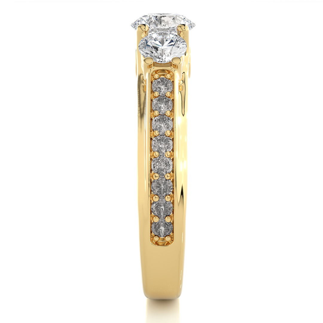 Side profile of 2 Ct Round Moissanite Three Stone Engagement Ring In Yellow Gold, highlighting the brilliant center moissanite stone, highlighting the prong setting.